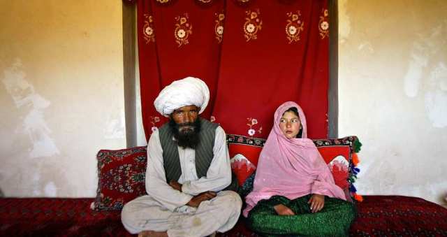 Faiz, 40 (left), and Ghulam (right), 11, sit in her home prior to their wedding in the rural Damarda Village, Afghanistan on September 11, 2005 